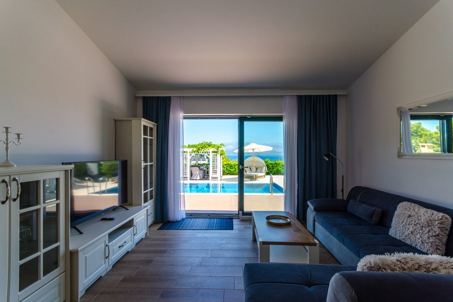 Wohnzimmer mit Zugang zur Terrasse und Poolblick
