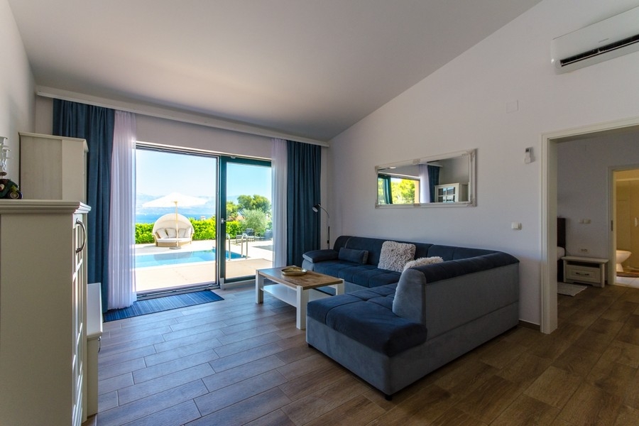 Wohnbereich mit Sofa und Terrassentür zum Swimmingpool