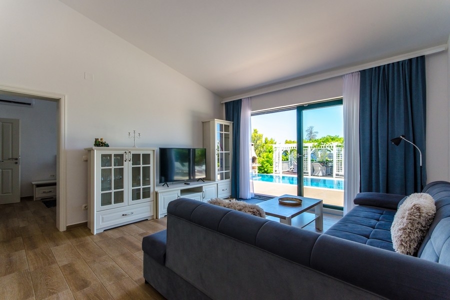 Wohnzimmer mit Blick zur Terrasse und Poolbereich