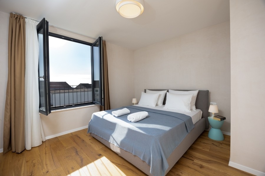 Schlafzimmer mit Doppelbett und geöffnetem Fenster