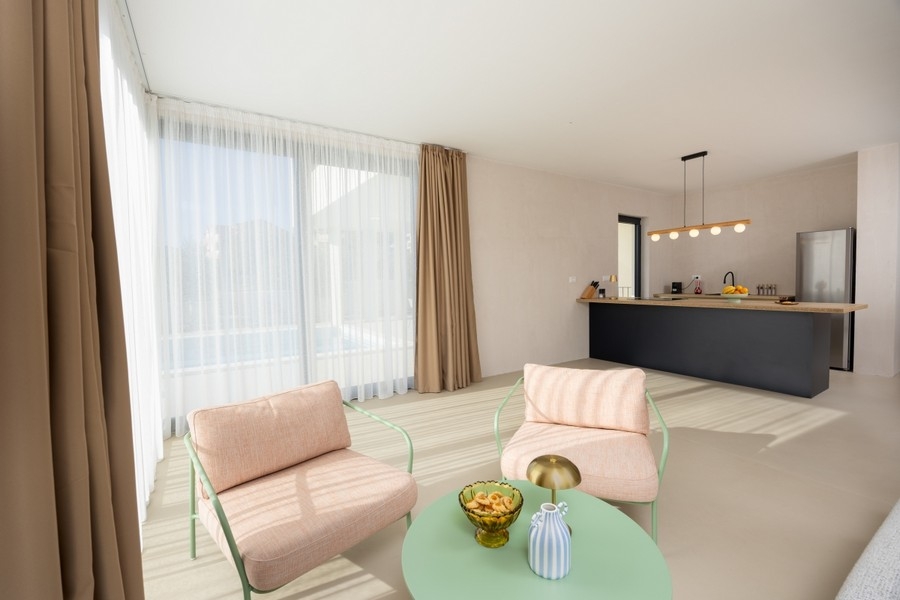 Offener Wohnbereich mit Küche und großen Fensterflächen