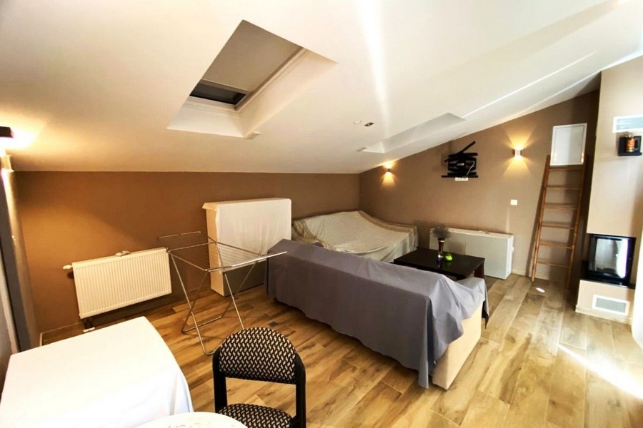 Wohnbereich im Dachgeschoss mit Kamin und Dachfenster