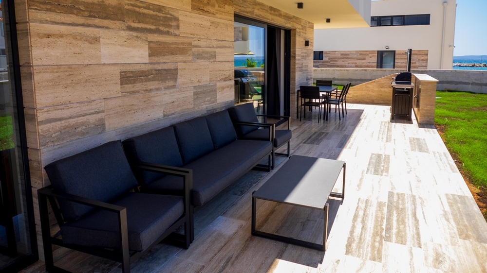 Überdachte Terrasse mit Lounge und Barbecue Bereich