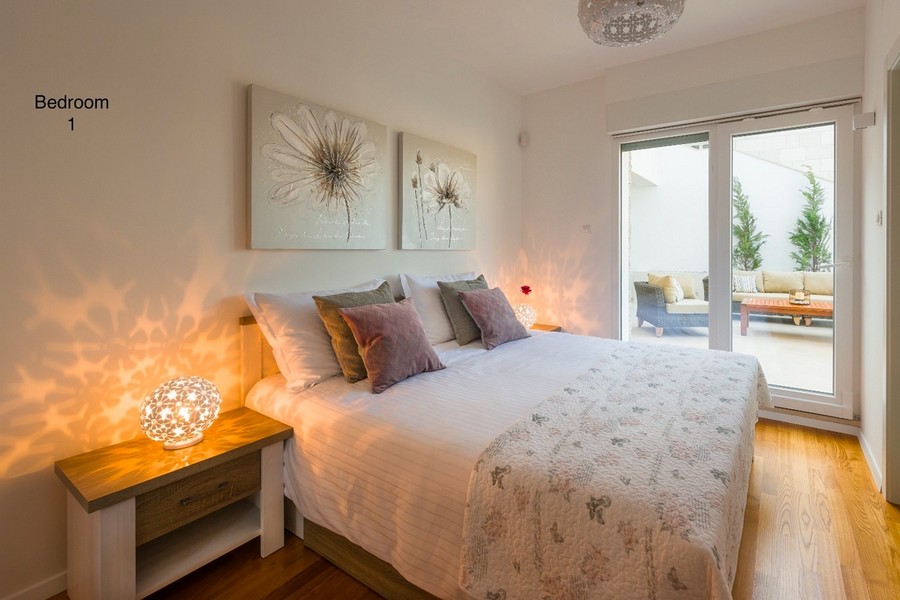 Schlafzimmer mit Doppelbett und Zugang zur Terrasse