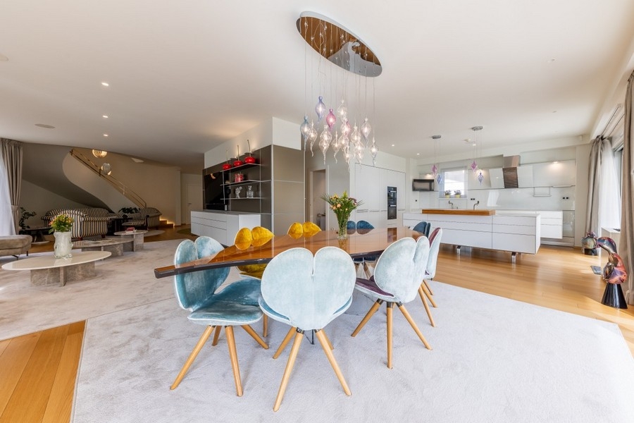 Offener Essbereich mit Designleuchte und moderner Küche