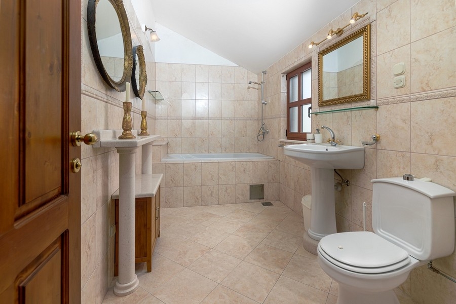 Badezimmer mit Badewanne und Natursteinoptik