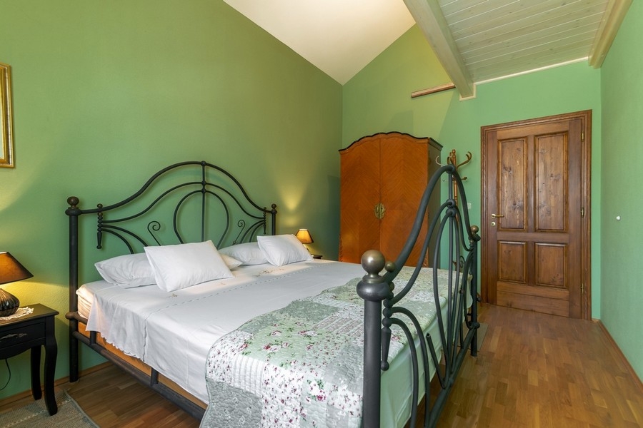 Schlafzimmer mit grünem Farbakzent und Holzboden