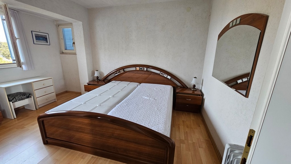Schlafzimmer mit Holzbett und Spiegel