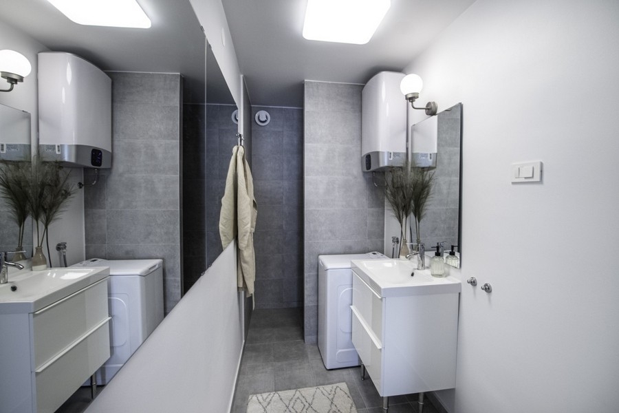 Modernes Badezimmer mit Waschmaschine und Waschbecken