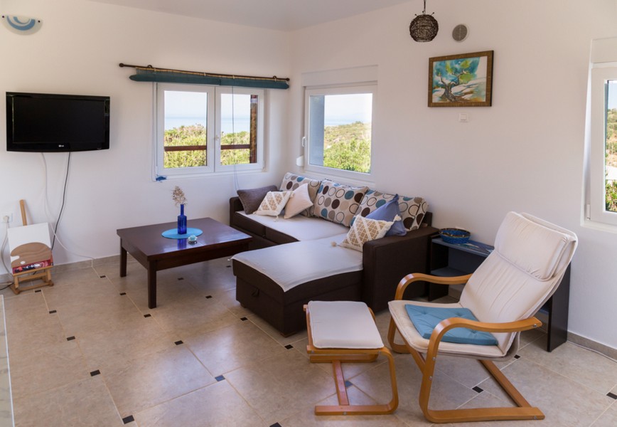 Wohnzimmer mit Sofa und Blick aufs Meer