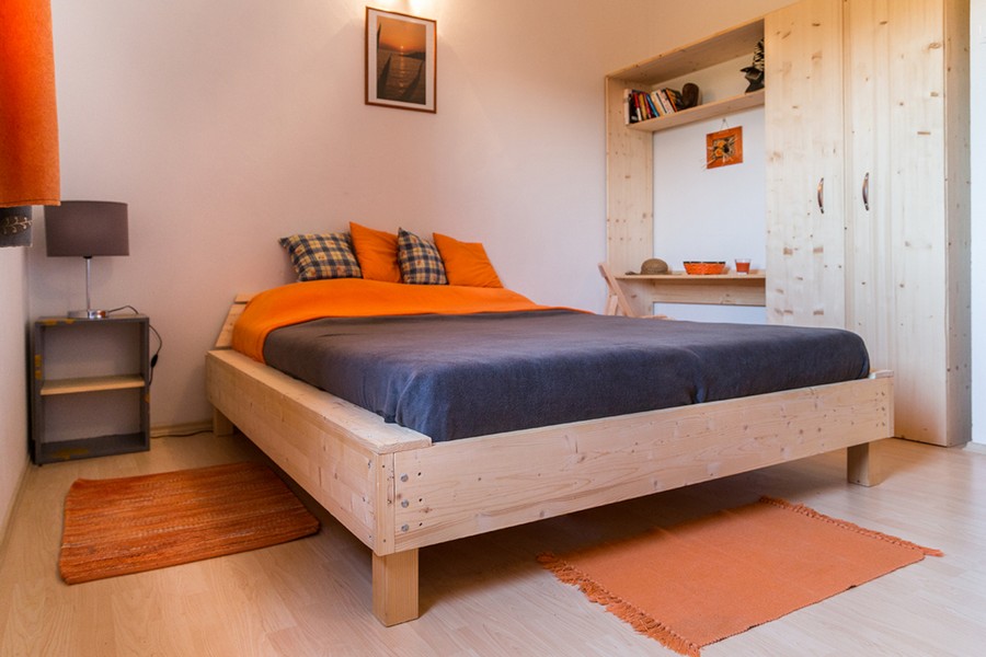 Schlafzimmer mit Holzbett und Einbauschrank