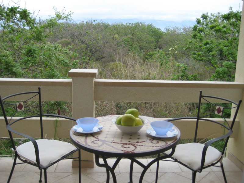 Balkon mit Tisch und Blick auf mediterrane Landschaft