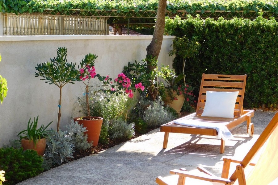 Terrasse mit Liegestuhl und mediterranen Pflanzen im Garten