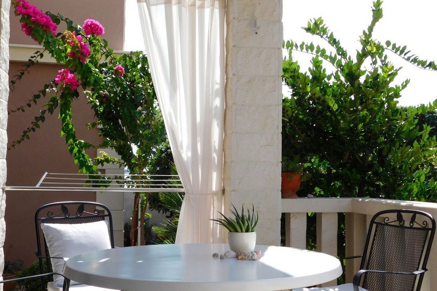 Überdachte Terrasse mit Sitzgruppe und Bougainvillea