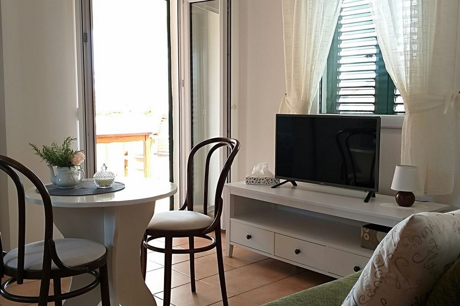 Wohnzimmer mit Esstisch und Zugang zur Terrasse