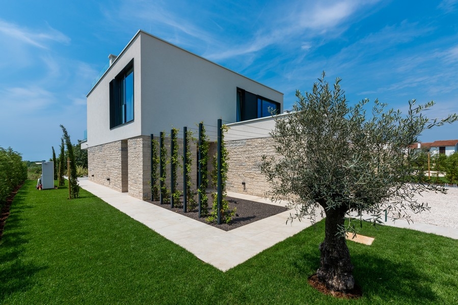 Seitenansicht der Villa mit Garten und Olivenbaum