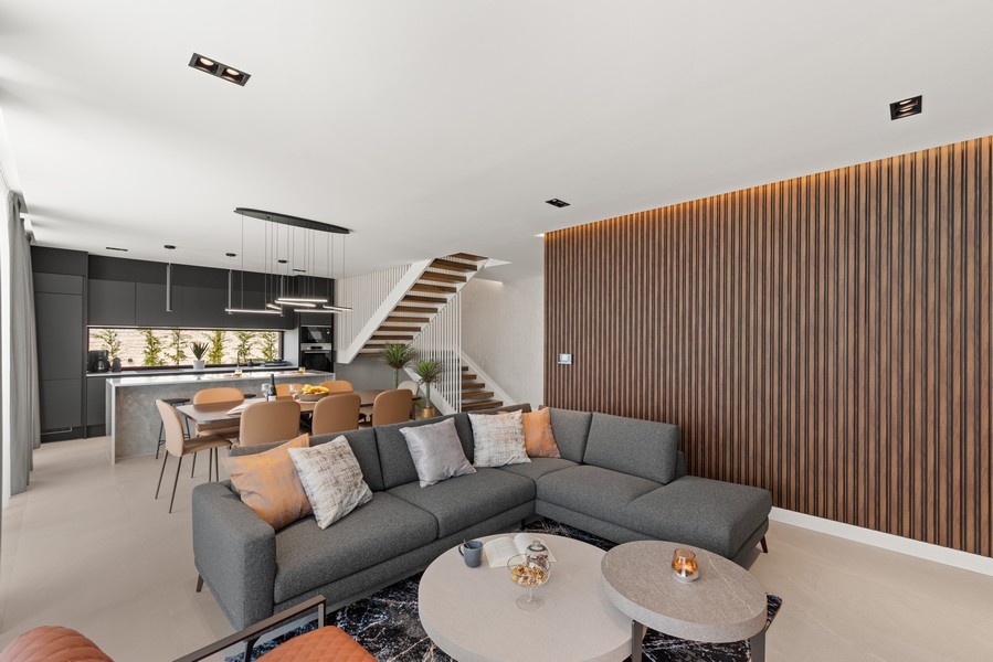 Wohnzimmer mit Designmöbeln und offener Küche