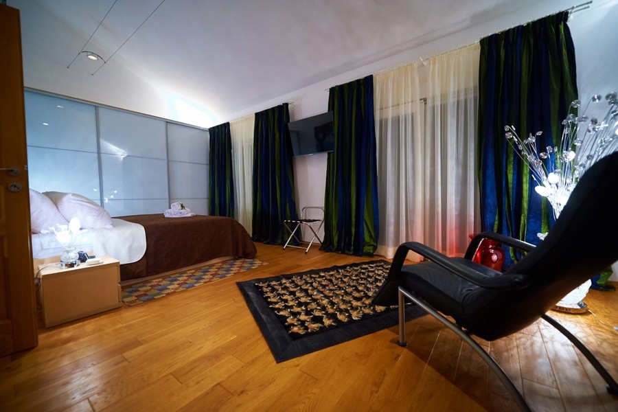 Geräumiges Schlafzimmer mit Parkettboden und Sitzbereich