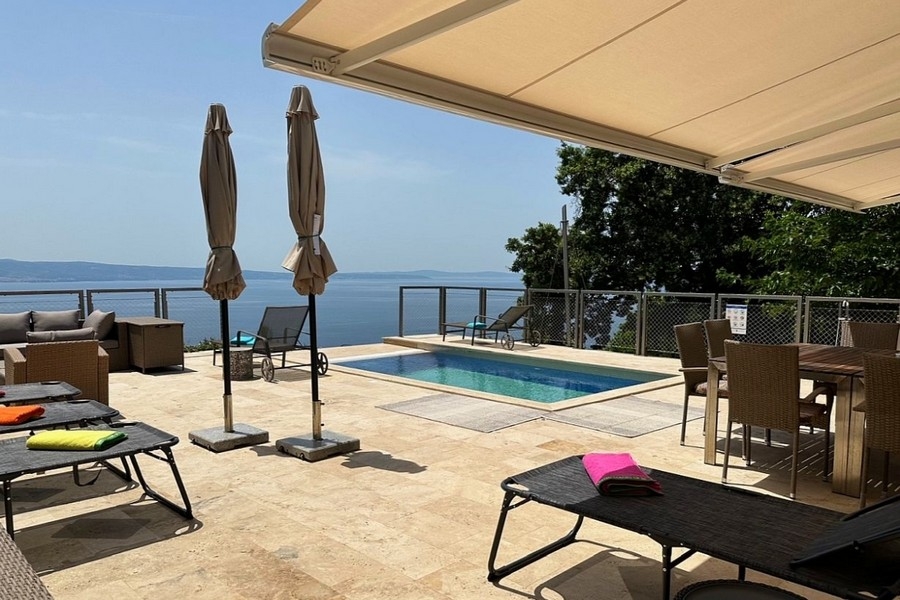 Sonnenterrasse mit Liegen und Blick auf das Meer