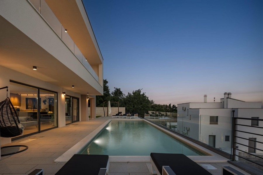 Moderne Villa mit Infinity Pool und Meerblick bei Abendstimmung