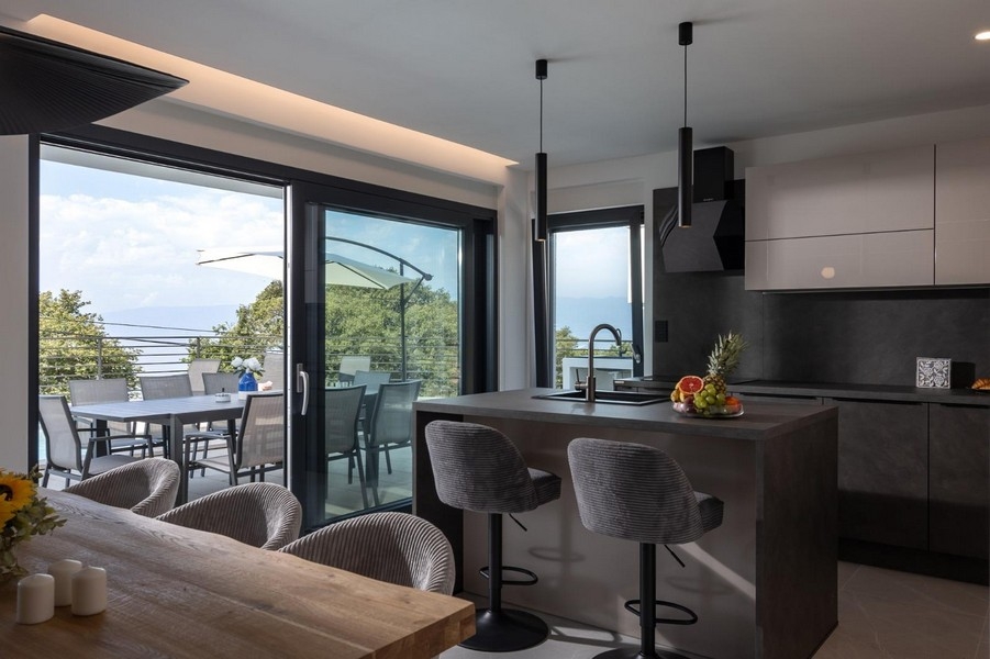 Offene Küche mit Kochinsel und Zugang zur Terrasse