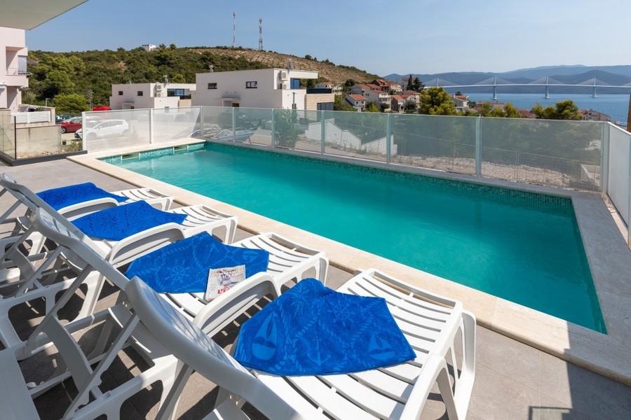 Helle Terrasse mit Swimmingpool und Blick auf die Küste