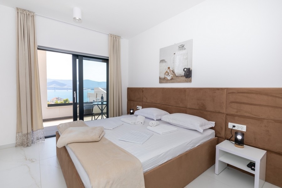 Schlafzimmer mit Doppelbett und Balkon mit Meerblick