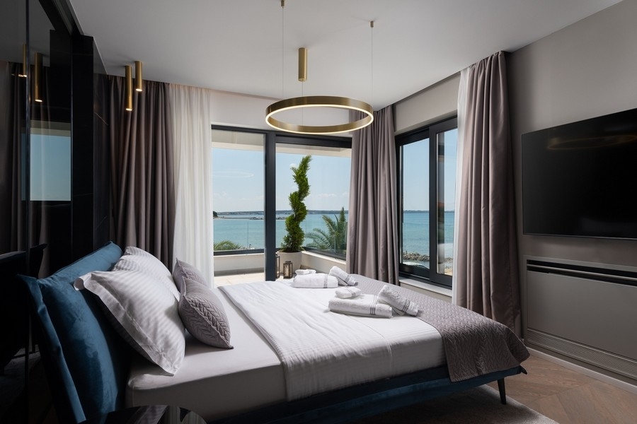Schlafzimmer mit großen Fenstern und Meerblick in Kroatien