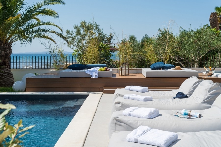 Poolbereich mit Sonnenterrasse und Meerblick an moderner Villa