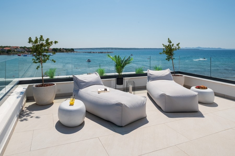 Dachterrasse mit Liegeflächen und Panoramablick auf das Meer