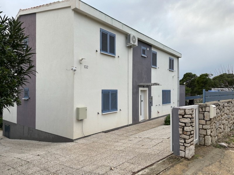 Hausfassade mit Eingangsbereich und Stellplatz auf eingezäuntem Grundstück in Kroatien