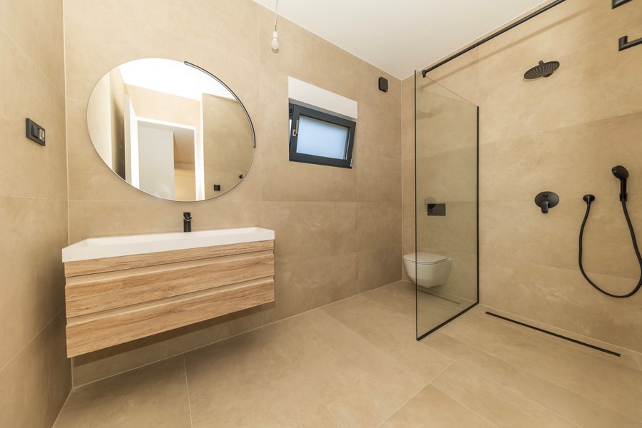 Badezimmer mit bodengleicher Dusche und moderner Ausstattung