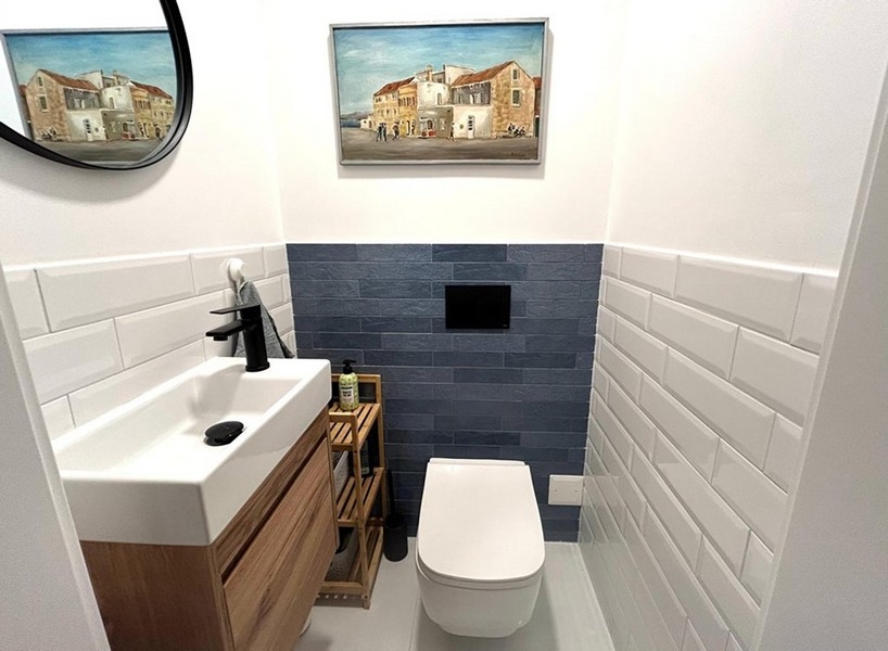 Separates WC mit Waschbecken und Wandfliesen