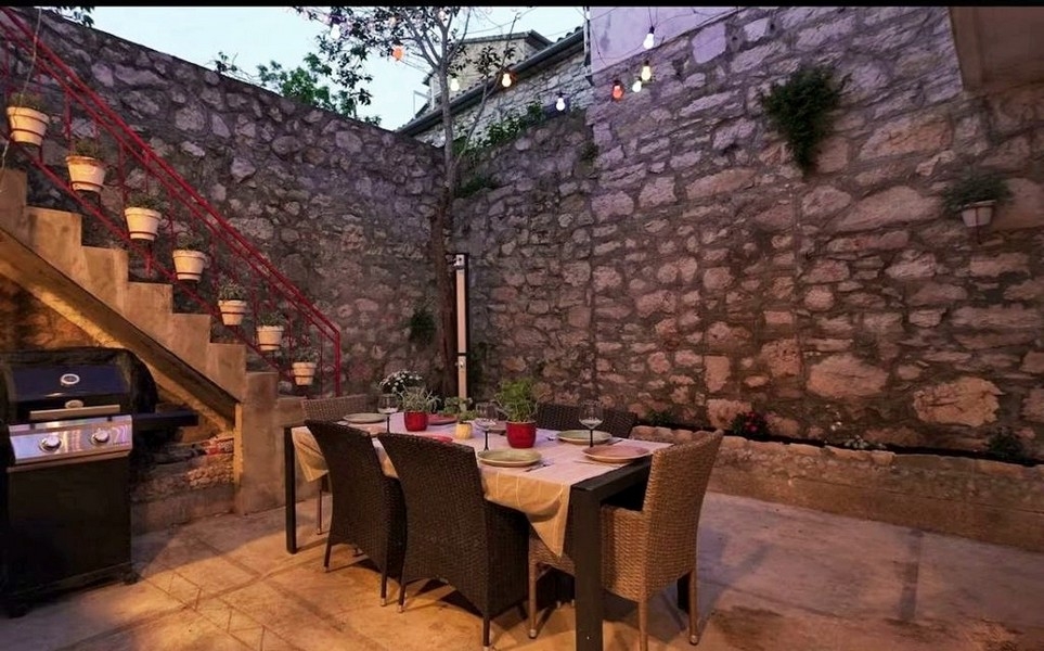 Innenhof mit Natursteinmauer und Sitzbereich im Außenbereich