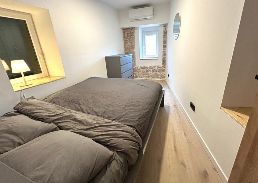 Schlafzimmer mit Doppelbett und sichtbarer Natursteinwand