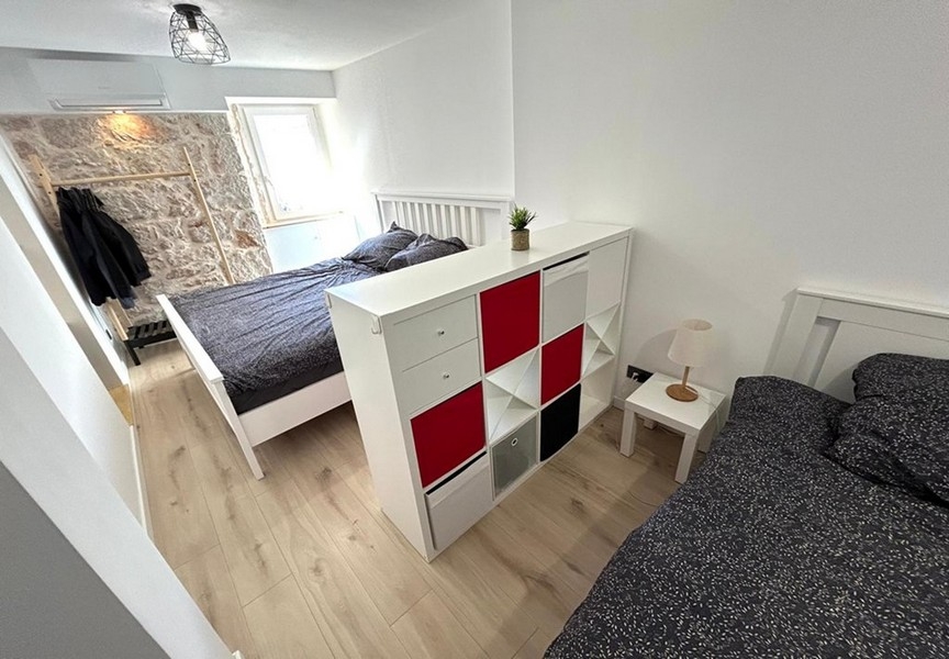 Schlafzimmer mit Doppelbett und Raumteiler