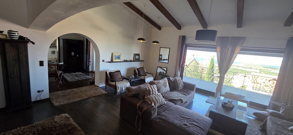 Wohnzimmer mit Zugang zum Balkon und Blick ins Umland