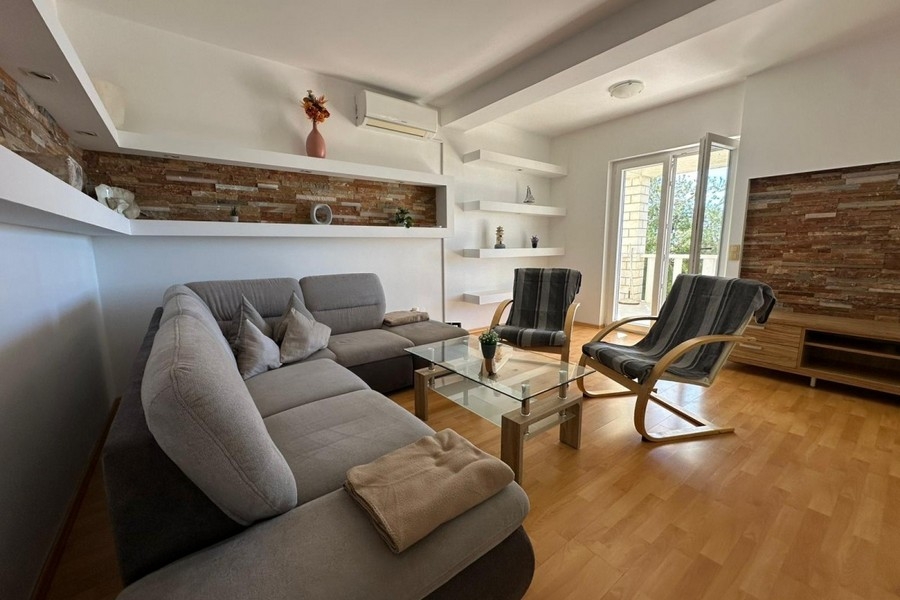 Wohnzimmer mit Sofa, Sessel und modernem Wanddesign