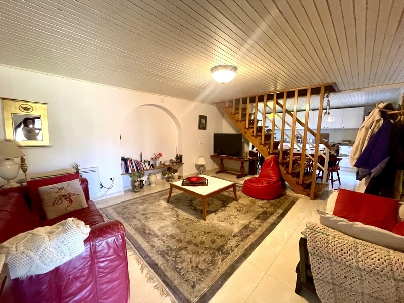 Wohnzimmer mit Sofa, Teppich und offener Treppe