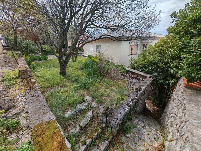 Treppen führen zum Haus hinunter.
