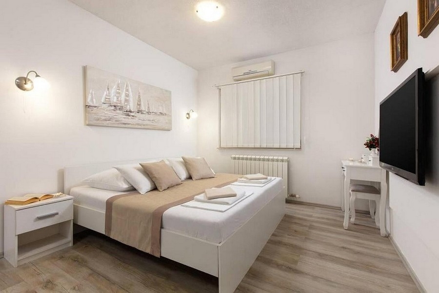 Modern eingerichtetes Schlafzimmer mit Klimaanlage und TV