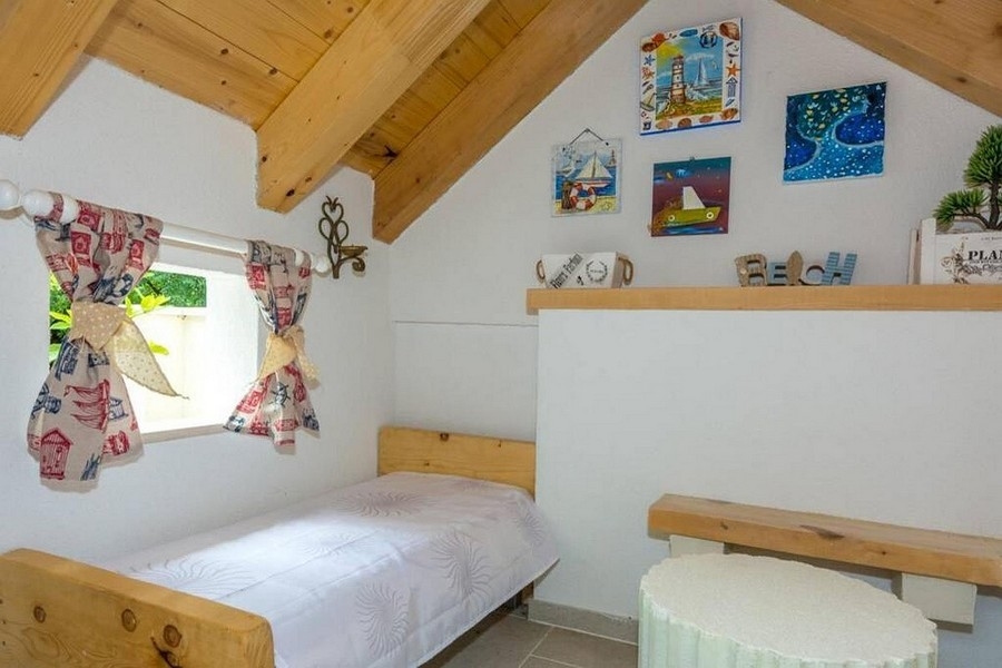 Schlafbereich im Dachgeschoss mit Holzbalken und gemütlicher Atmosphäre