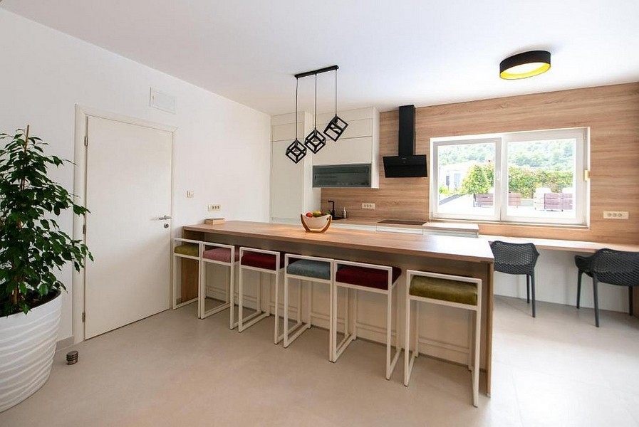 Offene Küche mit Kochinsel und Sitzgelegenheiten im modernen Stil