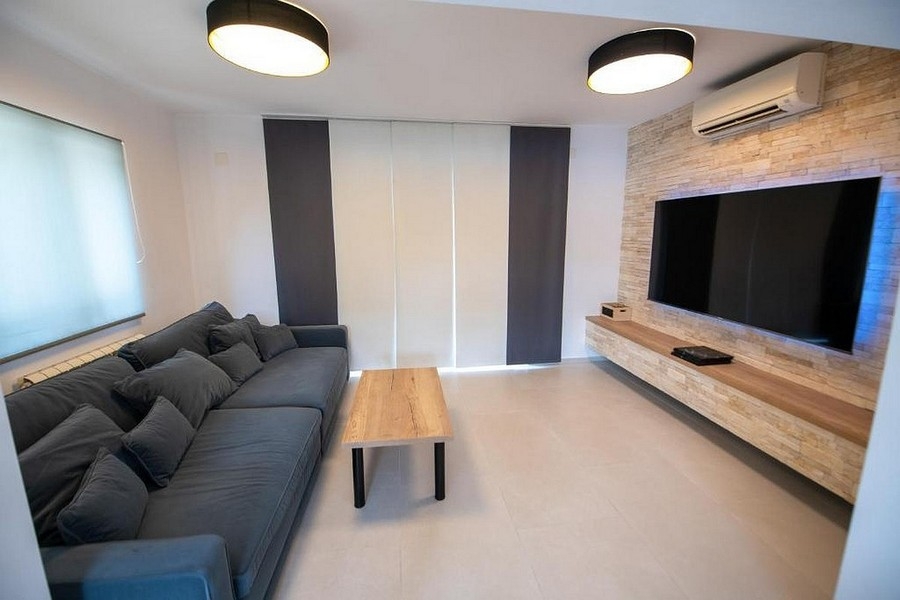 Wohnzimmer mit großer TV-Fläche und moderner Wandgestaltung