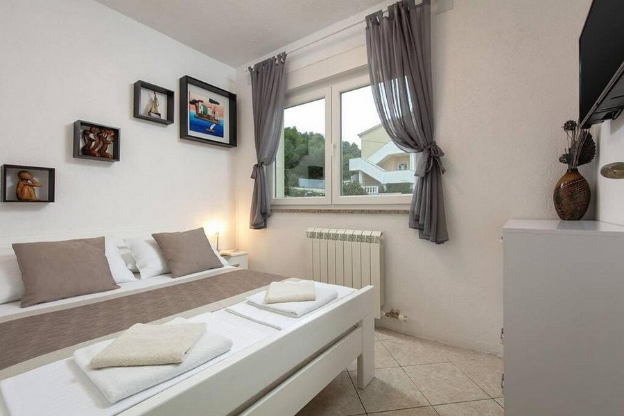 Schlafzimmer mit Doppelbett und Fenster mit Blick ins Grüne