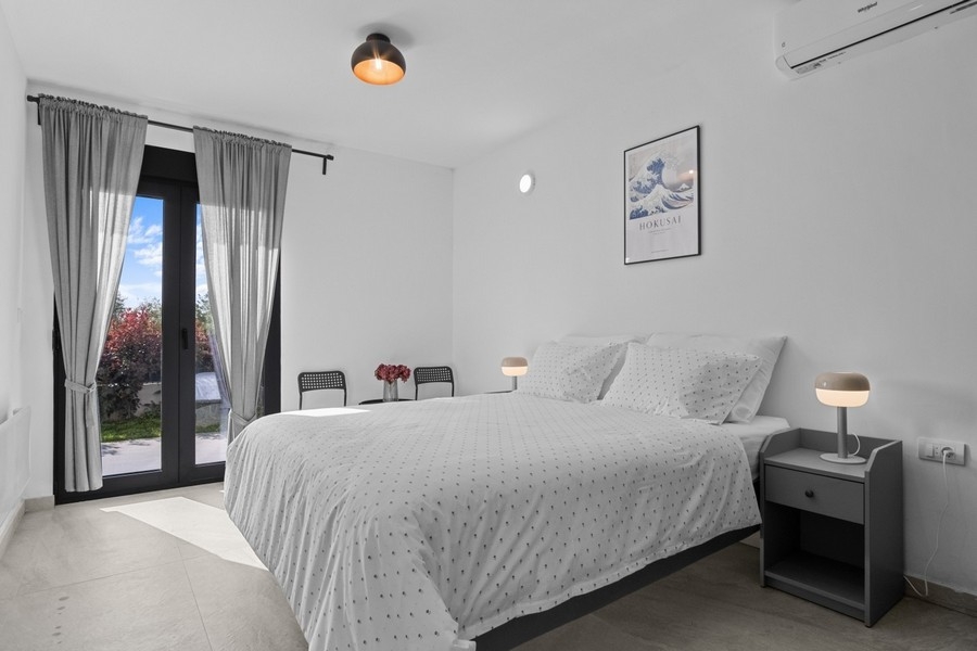 Schlafzimmer mit Doppelbett und Zugang zur Terrasse
