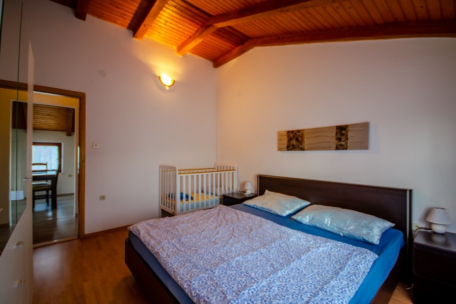 Schlafzimmer mit Doppelbett und Holzbalkendecke