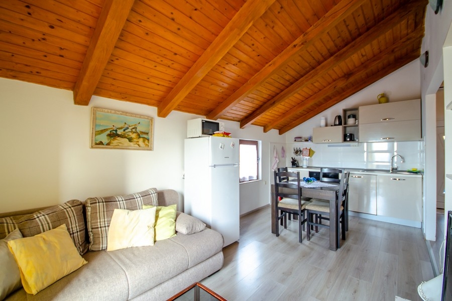 Wohn- und Essbereich mit offener Küche und Holzbalkendecke