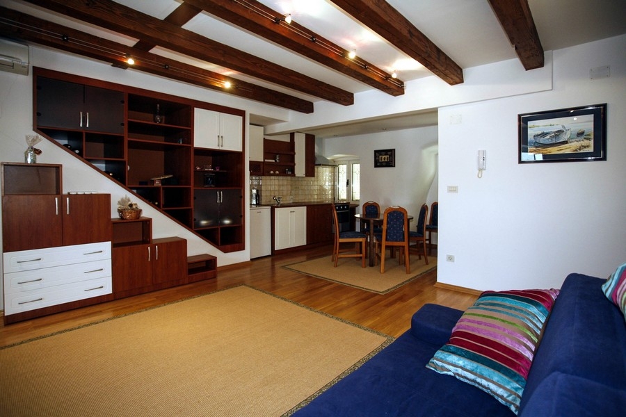 Wohnbereich mit offener Küche und sichtbaren Holzbalken