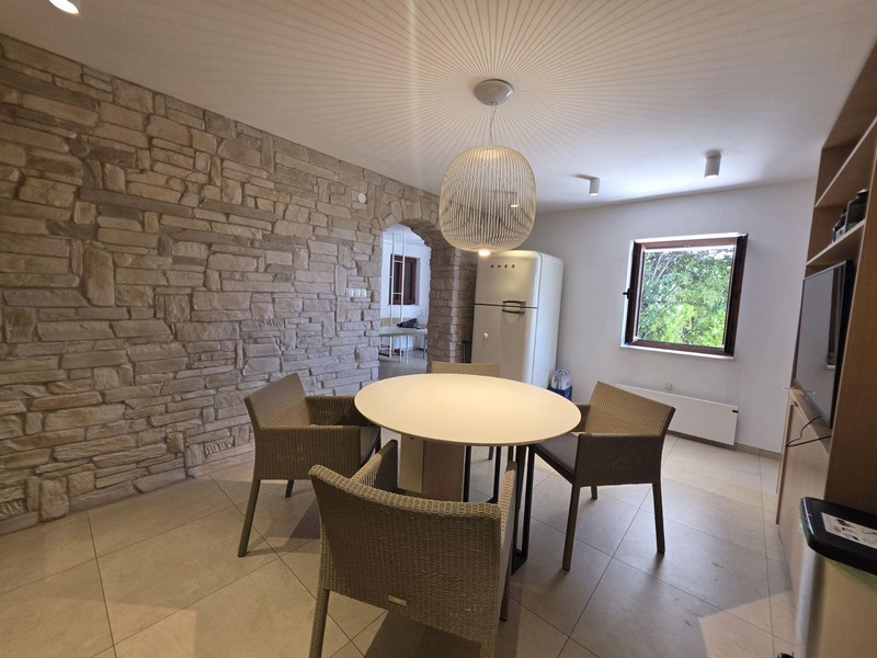 Küche mit Steinwand und modernem Essbereich